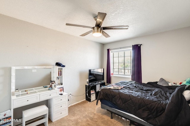 bedroom with baseboards, ceiling fan, light carpet, and a textured ceiling