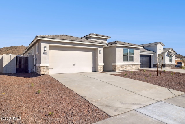 prairie-style house featuring stone siding, stucco siding, driveway, and a garage