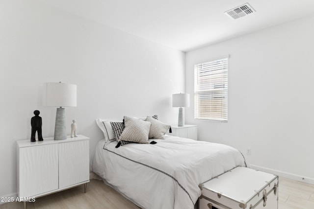 bedroom with visible vents, baseboards, and light wood-style floors