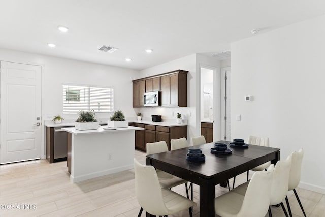 dining space with light wood-type flooring, recessed lighting, visible vents, and baseboards