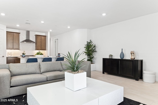 living area with recessed lighting, visible vents, and light wood-style floors