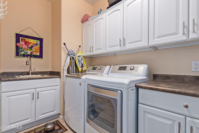 clothes washing area with cabinets, independent washer and dryer, and sink