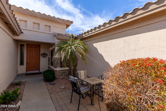 view of exterior entry featuring a patio