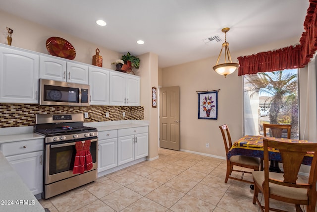 kitchen with decorative light fixtures, decorative backsplash, light tile patterned floors, stainless steel appliances, and white cabinets