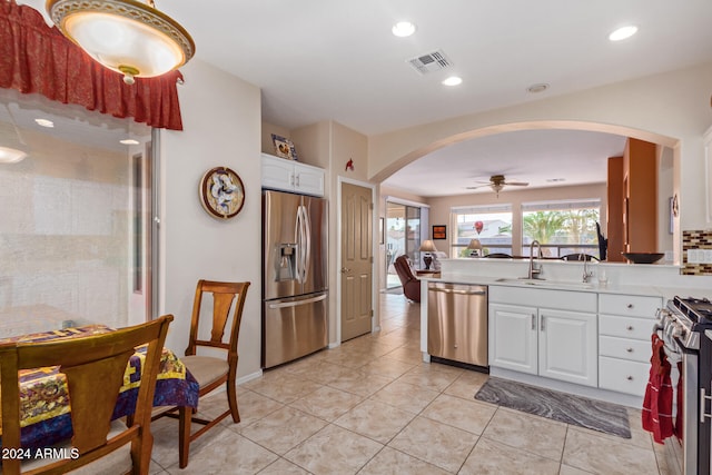 kitchen with ceiling fan, sink, white cabinetry, stainless steel appliances, and light tile patterned floors