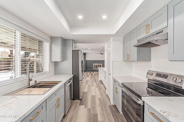 5721 W Palo Verde Ave, Glendale, AZ 85302 - kitchen featuring stainless steel appliances, gray cabinetry, under cabinet range hood, light wood-style flooring, and a raised ceiling