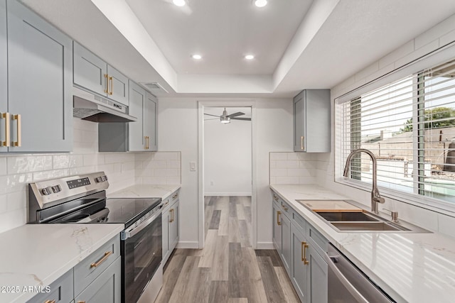 5721 W Palo Verde Ave, Glendale, AZ 85302 - kitchen with stainless steel appliances, gray cabinets, under cabinet range hood, a raised ceiling, and light wood-style floors