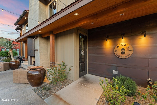 exterior entry at dusk with a patio area