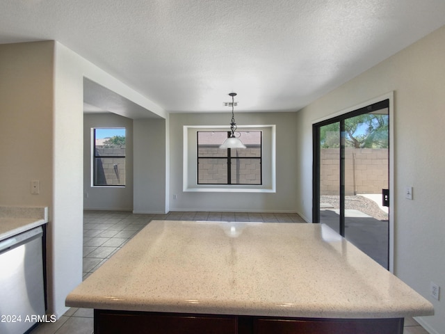 unfurnished dining area featuring light tile flooring and a textured ceiling