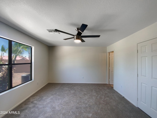 empty room with a textured ceiling, carpet floors, and ceiling fan