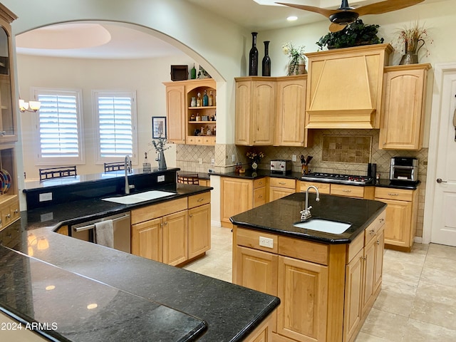 kitchen with light brown cabinets, a center island with sink, appliances with stainless steel finishes, and sink