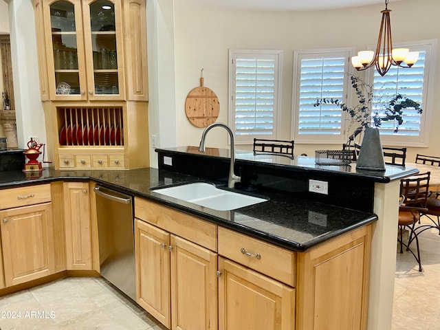 kitchen with light brown cabinetry, dark stone counters, sink, a notable chandelier, and dishwasher