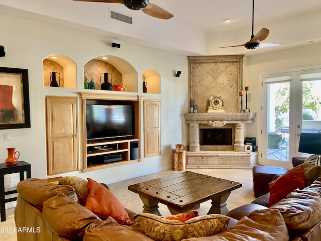 tiled living room featuring built in shelves, ceiling fan, and a premium fireplace