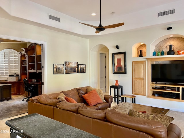 tiled living room with built in shelves and ceiling fan