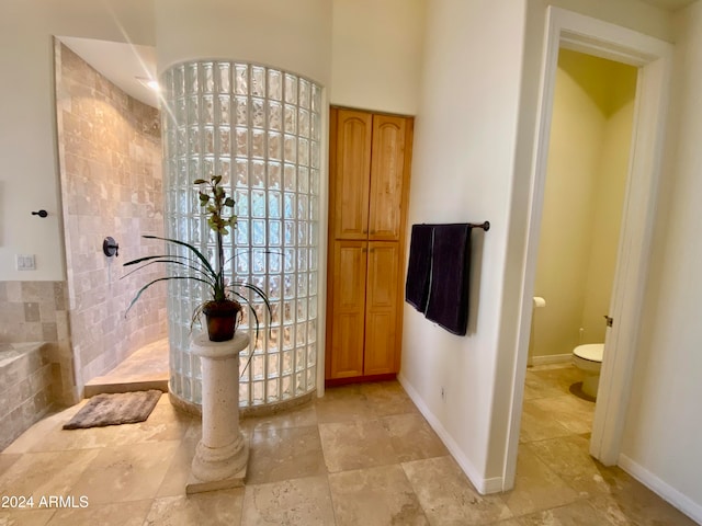 bathroom with toilet and tile walls