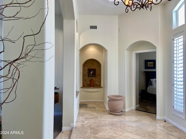 hallway with a notable chandelier