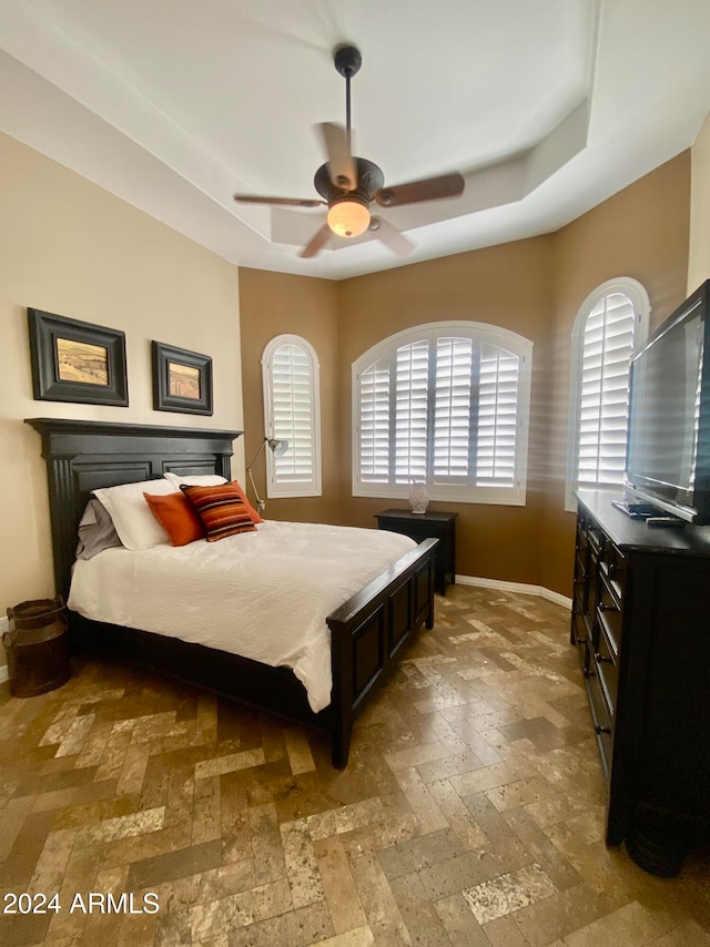 bedroom featuring a tray ceiling and ceiling fan