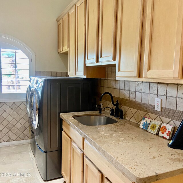 clothes washing area featuring cabinets, independent washer and dryer, and sink