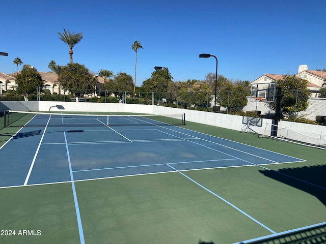 view of tennis court with basketball hoop