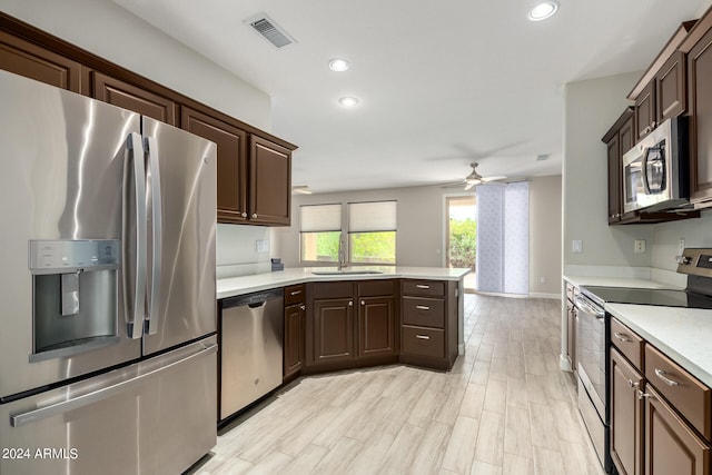 kitchen featuring dark brown cabinets, light hardwood / wood-style floors, appliances with stainless steel finishes, and ceiling fan