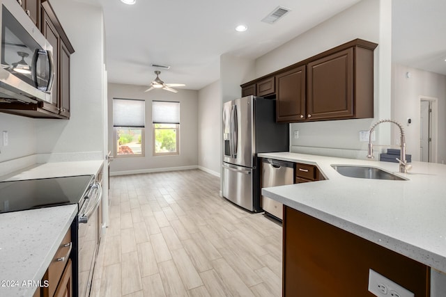 kitchen featuring light hardwood / wood-style flooring, ceiling fan, appliances with stainless steel finishes, dark brown cabinetry, and sink