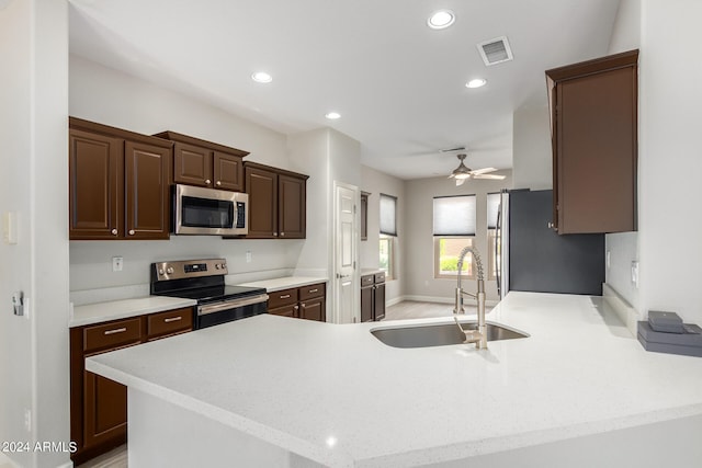 kitchen with ceiling fan, stainless steel appliances, sink, dark brown cabinetry, and kitchen peninsula