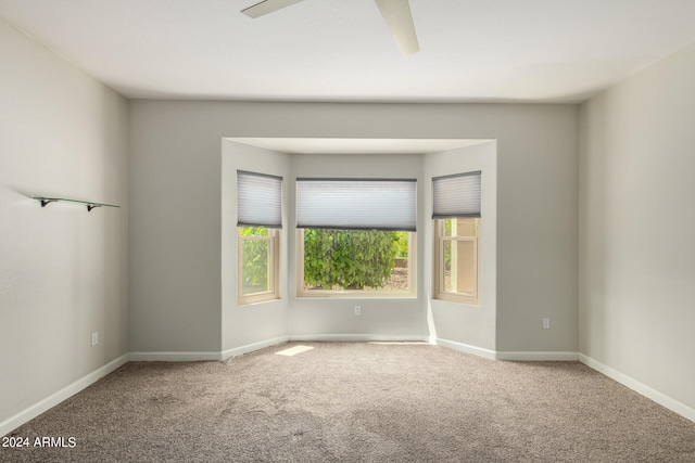 carpeted spare room with ceiling fan