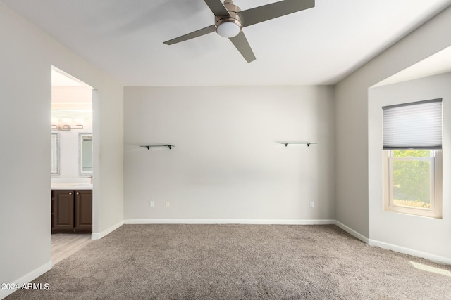 empty room with light colored carpet and ceiling fan