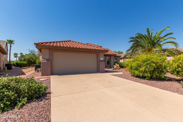 view of front of house with a garage and cooling unit