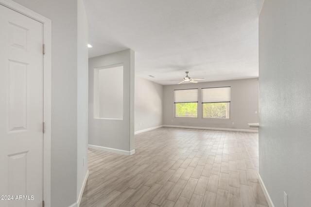 unfurnished room with ceiling fan and light wood-type flooring