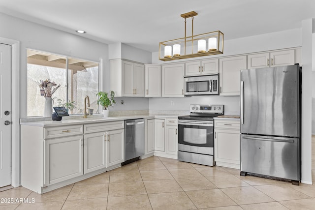 2313 N 87th Way, Scottsdale, AZ 85257 - kitchen with stainless steel appliances, a sink, light countertops, light tile patterned floors, and decorative light fixtures