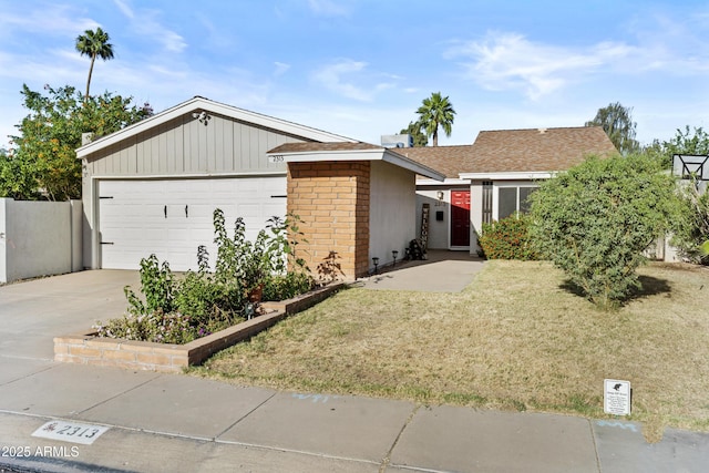 2313 N 87th Way, Scottsdale, AZ 85257 - view of front of home featuring a garage, brick siding, roof with shingles, a front lawn, and driveway