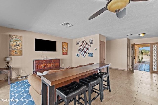 tiled dining room featuring a textured ceiling and ceiling fan