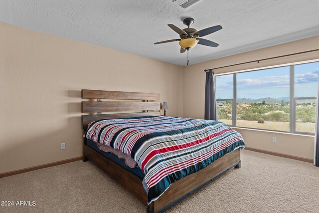 bedroom with carpet floors, a textured ceiling, and ceiling fan