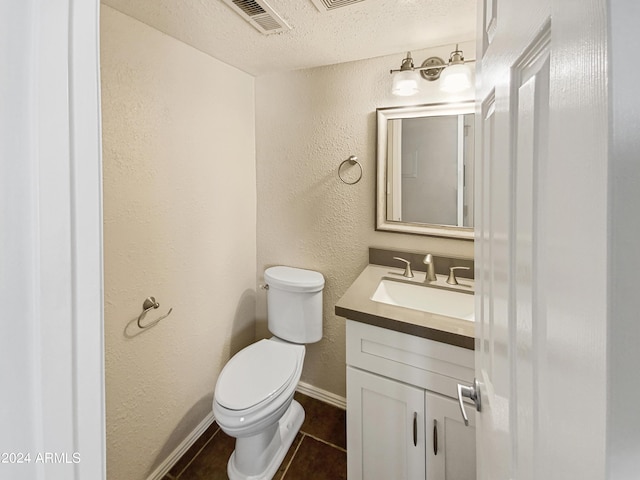 bathroom featuring tile patterned floors, vanity, a textured ceiling, and toilet