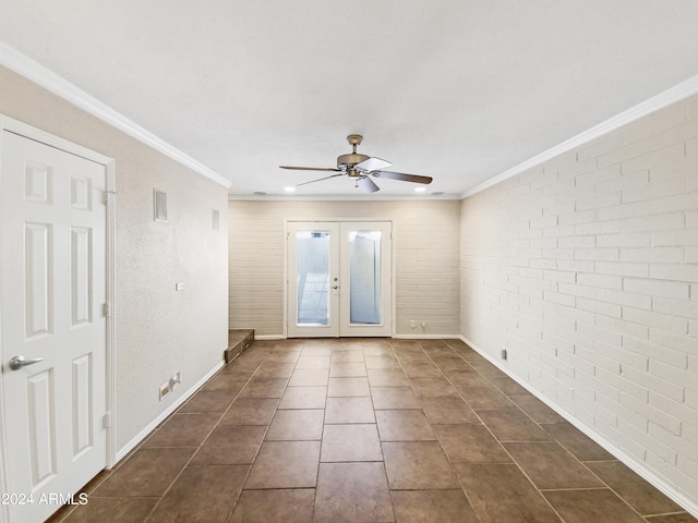 tiled spare room with ceiling fan, ornamental molding, brick wall, and french doors