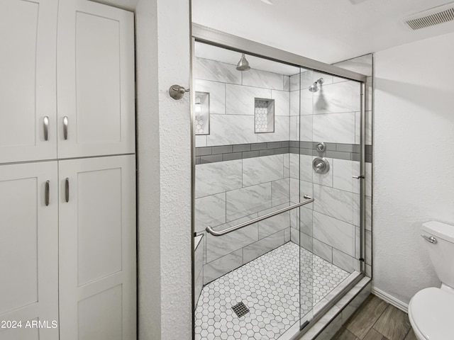 bathroom featuring walk in shower and toilet