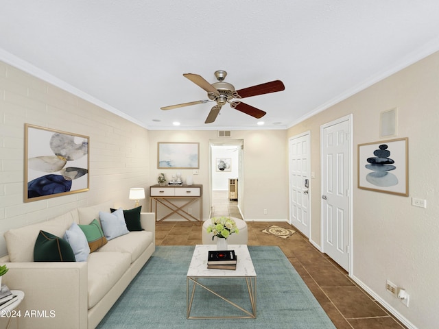 living room featuring dark tile patterned flooring, ceiling fan, and crown molding