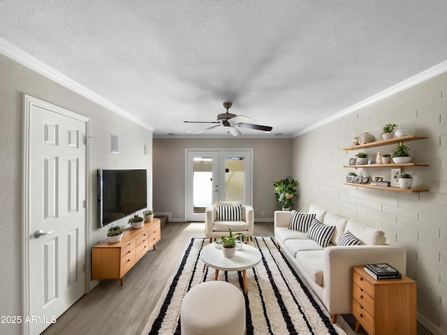 4925 N 73rd St Unit 4, Scottsdale, AZ 85251 - living room featuring crown molding, light wood-style flooring, french doors, a ceiling fan, and a textured ceiling