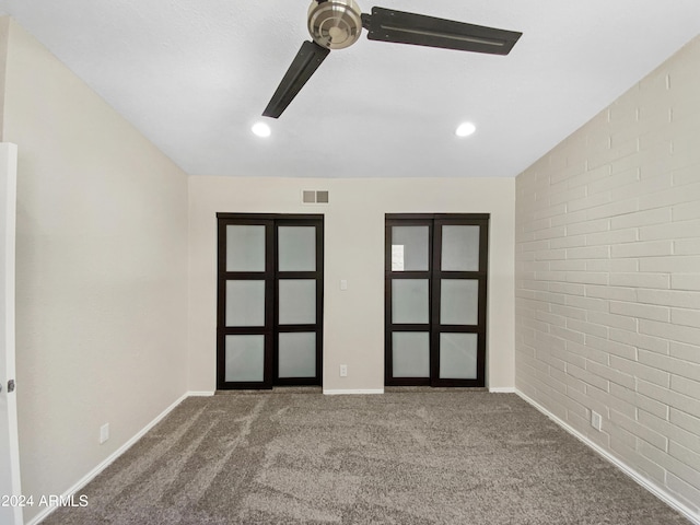 unfurnished room with carpet and brick wall