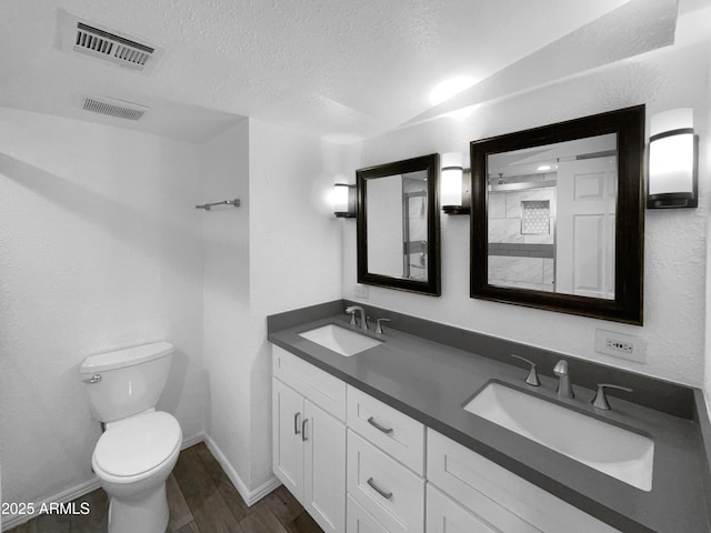 4925 N 73rd St Unit 4, Scottsdale, AZ 85251 - bathroom featuring toilet, double vanity, a textured ceiling, wood finished floors, and baseboards