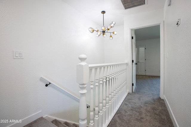 staircase with carpet floors, a chandelier, visible vents, and baseboards