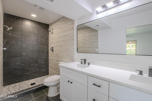 full bathroom featuring toilet, visible vents, a sink, and tiled shower