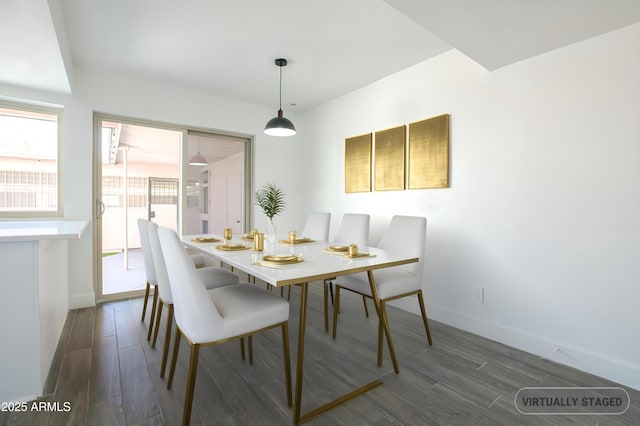 dining area featuring baseboards and dark wood-type flooring