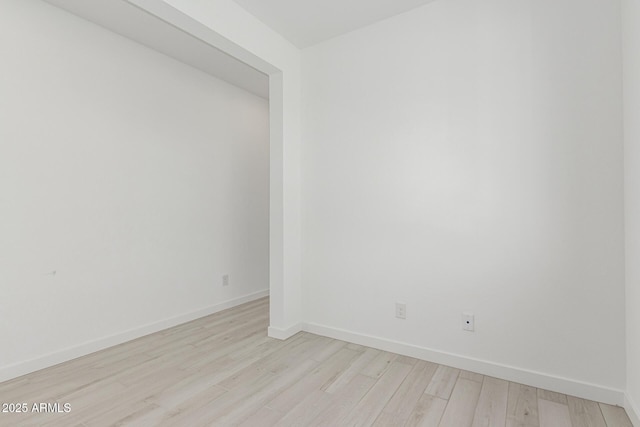 spare room with light wood-type flooring and baseboards