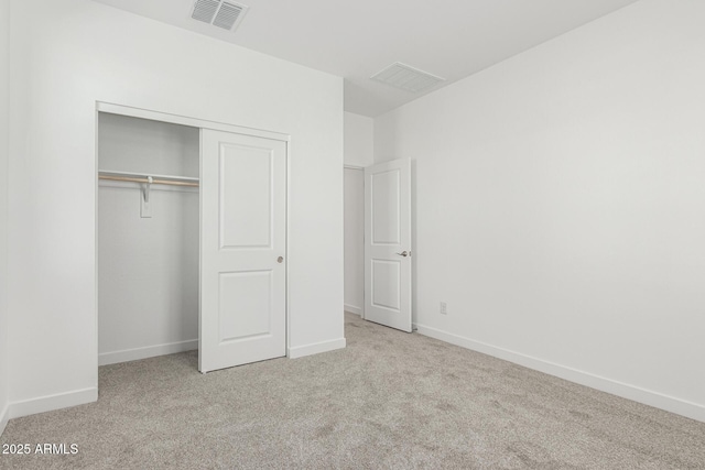 unfurnished bedroom with carpet floors, a closet, visible vents, and baseboards