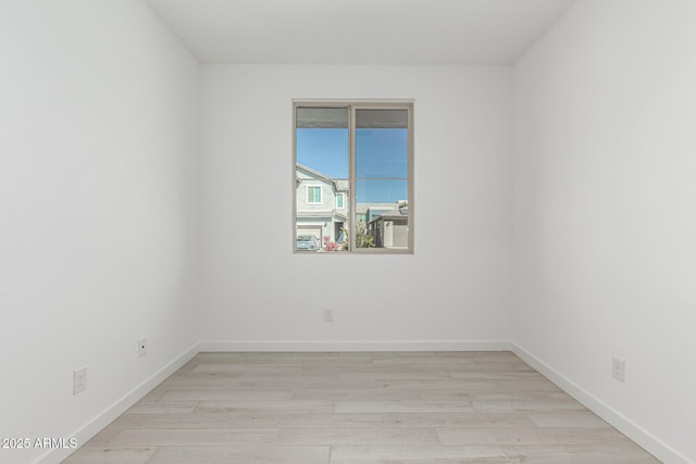 spare room with light wood-style flooring and baseboards