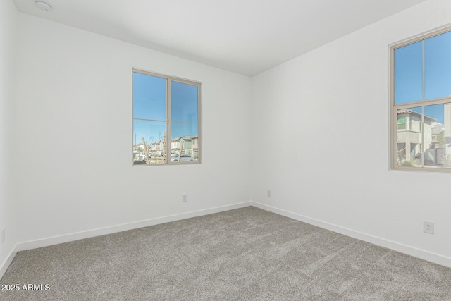 unfurnished room with carpet and baseboards