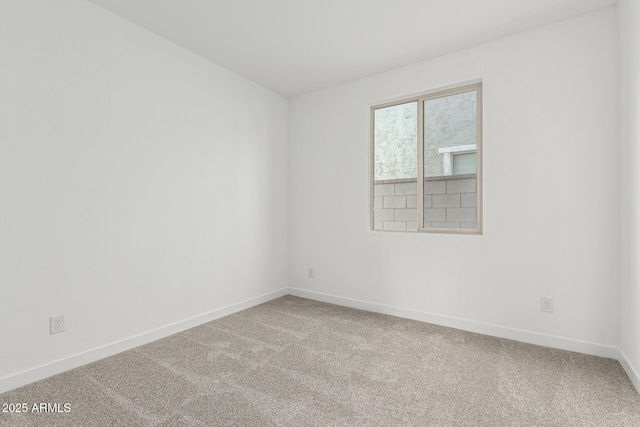 carpeted spare room featuring baseboards