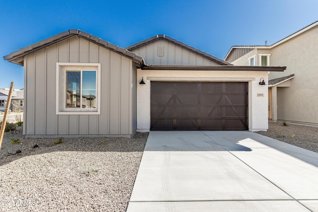 single story home featuring driveway, an attached garage, and board and batten siding